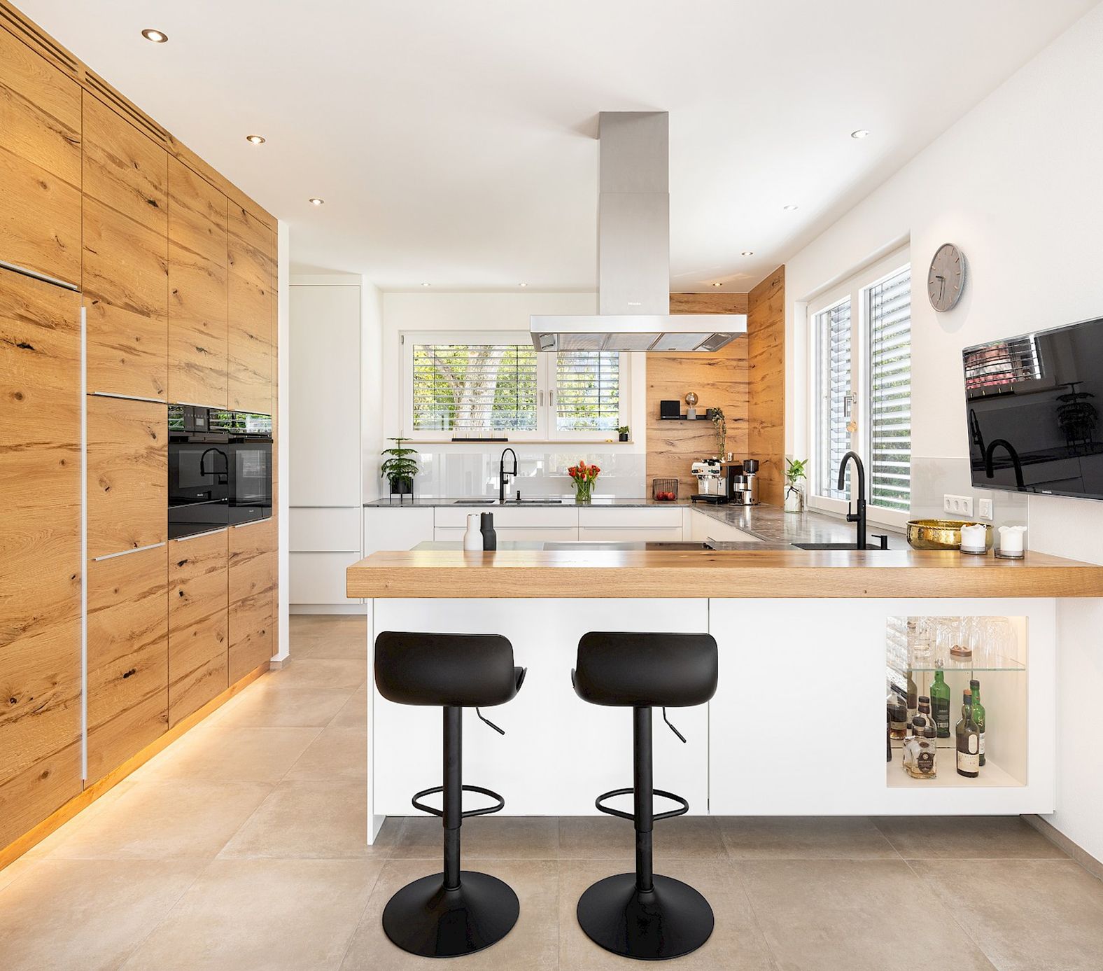 Moderne Küche mit Holzfronten, Kochinsel und Barhockern